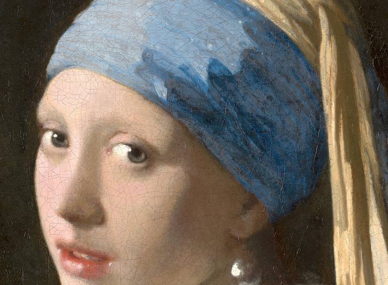 Detail of Girl with a Pearl Earring showing her eyes, the blue turban and the fine craquelure across the paint surface